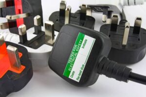 Multiple PAT tested UK plugs showing test sticker