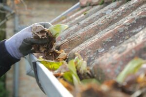 cleaning autumn leaves out of roof guttering